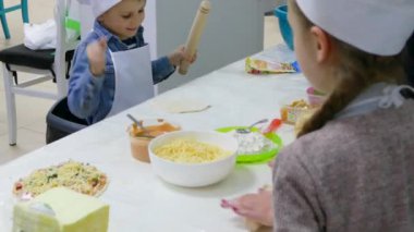 Erkek ve kız kardeş mutfakta yemek pişiriyor.