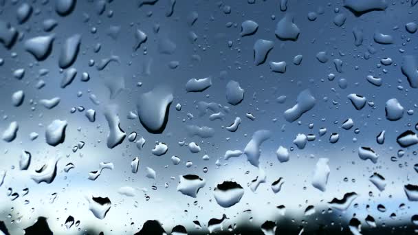 Regentropfen fließen durch das Fenster. Schlechtes Wetter vor dem Fenster. — Stockvideo