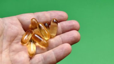 Elindeki kapsüllerde Omega 3 vitamini var. Balık yağı al. El vitamini al. Sağlıklı bir yaşam tarzı. Sağlıklı kalp ve kan damarları.