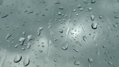 Pencerenin dışında kötü hava var. Yağmur yağıyor ve bardaktan aşağı su damlaları akıyor. Gri sonbahar bulutları. 4K.