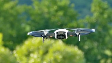 Kuadrokopter havadayken izliyor. İnsansız hava aracı yeşil arka planda uçar. Havadan çekim yapmak..