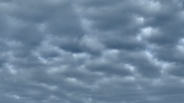 Nuvole grigie chiudono il cielo blu. Sta arrivando una tempesta e un uragano. Le nuvole volano veloci attraverso il cielo . — Video Stock