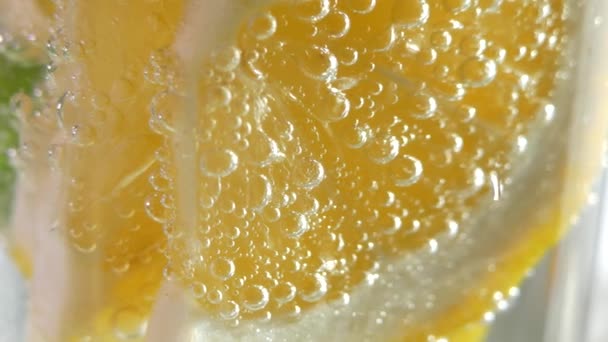 爽やかなソフトドリンクです モヒートはガラスのクローズアップに注がれます レモンミントと氷と輝く水 — ストック動画