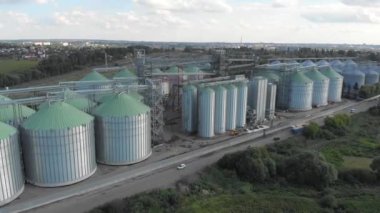 Asansör ve tahıl ambarı ayçiçekleri olan bir tarlanın arka planında. Tarım endüstrisi.