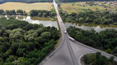 Hareket halindeki arabalarla otoyol. Nakliye kavşağı. Lojistik ve mal teslimatı. Köprüde kamyonlar.