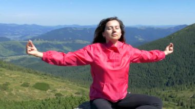 Kız dağın tepesinde oturur ve meditasyon yapar. Doğada rahatla. Mutluluk ve sükunet