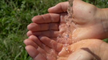 Su, bir dereden ellerin avuçlarına akar. Doğadan saf su.
