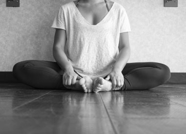 Siyah ve beyaz kadın dansçı pratik yoga stüdyo kelebek poz oturarak sürümü
