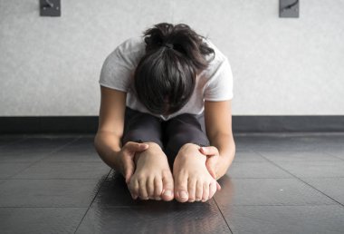 Genç kadın gerçekleştirme ve sit ve reach hamstrings germek ve esnekliği artırmak