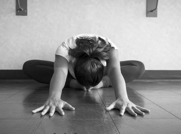 Black and white version of Yoga dancer Hip stretch in butterfly position reaching forward head to feet