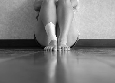 Bir mola için oturan bir ayak bileği burkulma ile Atlet siyah ve beyaz versiyonu 