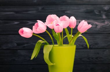 parlak ışık yeşil vazo siyah ahşap zemin ile bahar pembe laleler