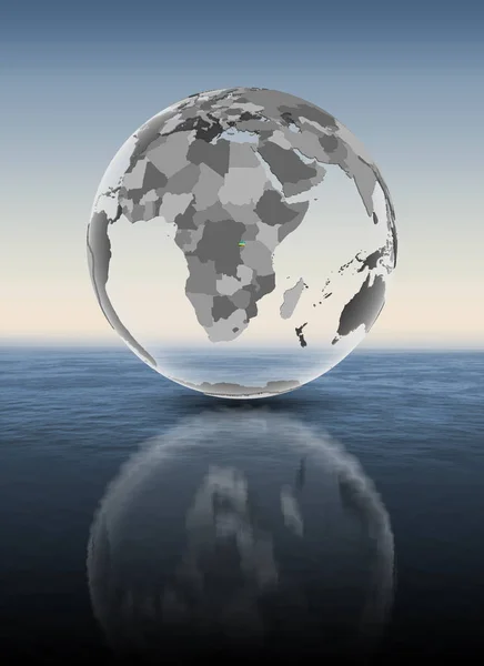 Rwanda with flag on translucent globe above water. 3D illustration.