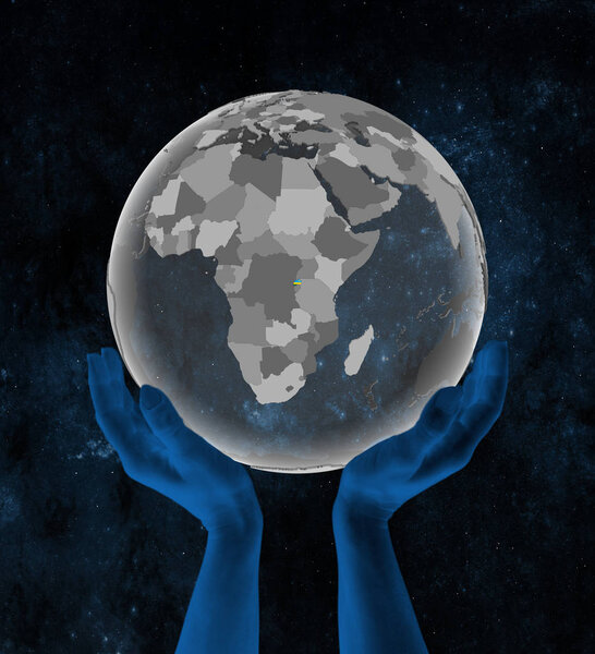 Rwanda With flag on translucent globe in hands in space. 3D illustration.