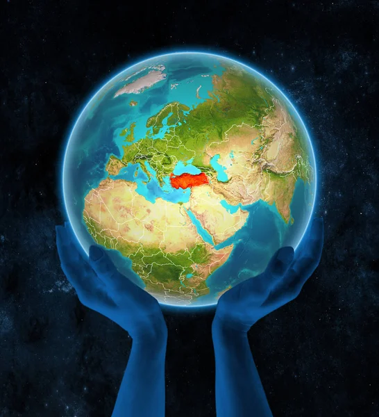 Turkey on planet Earth with visible country borders in hands in space. 3D illustration.