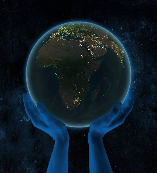 Rwanda on night Earth in hands in space. 3D illustration.