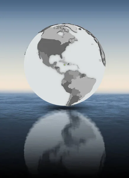 Jamaica with flag on globe above water. 3D illustration.