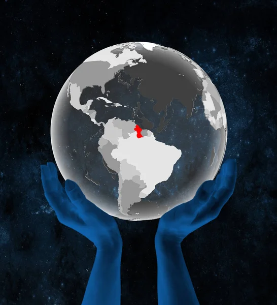 Guyana on translucent globe in hands in space. 3D illustration.