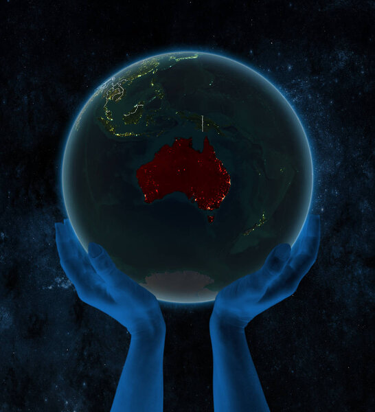 Australia on night planet Earth with visible country borders in hands in space. 3D illustration.