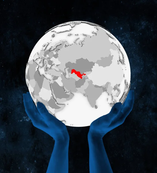 乌兹别克斯坦以红色在白色地球手在空间举行 — 图库照片
