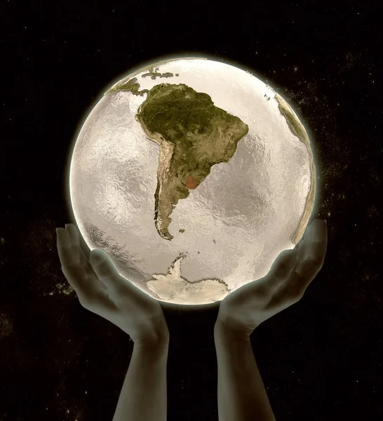 Uruguay on globe in hands in space. 3D illustration.