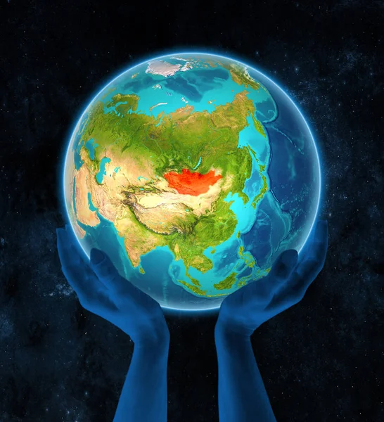 Mongolia in red on globe held in hands in space. 3D illustration.