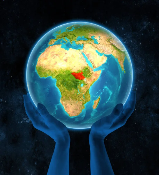 South Sudan in red on globe held in hands in space. 3D illustration.