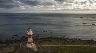 Güzel Cape Palliser fener Yeni Zelanda Timelapse video. Uçan bulutlar hızlı ve güçlü rüzgar tarafından neden olduğu dalgalanmalar su. Güzel bir akşam ışık.