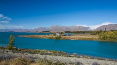 Ünlü güneşli yaz gününde Lake Tekapo, Yeni Zelanda kıyısında Good Shepherd Kilisesi Timelapse. Güney Adası ve turistik cazibe en güzel yerlerden biri.