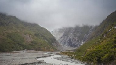 Yeni Zelanda dağlar bulutlar gibi görünen etkileyici Franz Josef glacier temizleyin. Timelapse video.