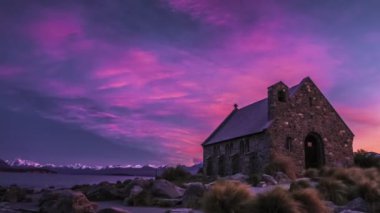Timelapse, Güneş doğmadan önce muhteşem mor gökyüzü altında güzel Lake Tekapo kıyısında Good Shepherd Kilisesi. Yeni Zelanda'da ikonik müteşekkil.