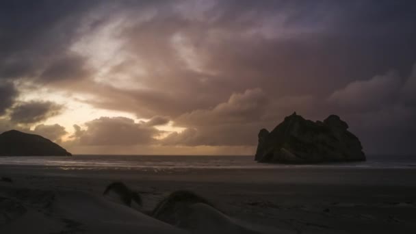 劇的な雲の海の上を渡すと美しいビーチでリラックスした夜のタイムラプス ビデオ ニュージーランド Wharariki ビーチの海岸での撮影します — ストック動画