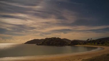 Gece timelapse yıldız ve zaman zaman bulut hareketli güzel bir kumsalda bulunan Yeni Zelanda.