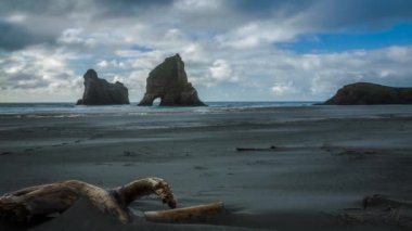 Yeni Zelanda'da güzel Plajı ile taş yığınları ile denizde kemerler. Timelapse video. Wharariki Beach.