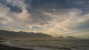 Akşam Kaikoura, Yeni Zelanda'da plaja Timelapse. Gökyüzünde güzel bulut formasyonları.