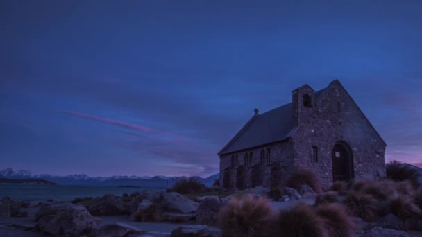 ニュージーランドの美しい風景に囲まれたテカポ湖の銀行に日の出前に の早朝に善き羊飼いの教会 南の島の主要な観光名所 タイムラプス ビデオ — ストック動画