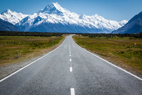 Scenic road to Mount Cook National Park in Southern Alps, New Zealand. Iconic view with the highest peak, Mount Cook as the dominant feature of the snowy mountain range.