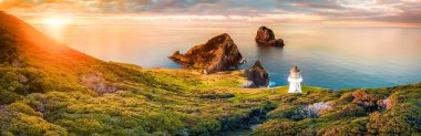 Cape Brett deniz feneri günbatımı sırasında Yeni Zelanda sahil üzerinde doğal Panoraması. Bay Islands, popüler turizm doğal güzelliği için yer alan.