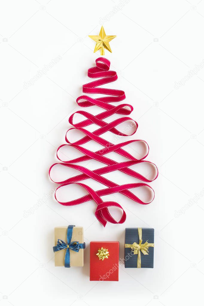 Flat lay view of a conceptual Christmas tree form by ribbon and gift boxes.
