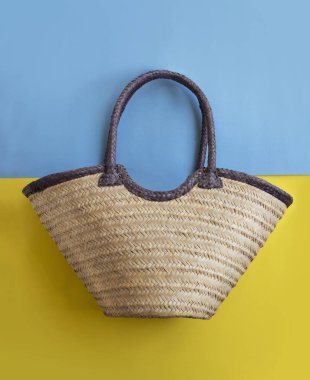 Hasır çanta düz yatıyordu görünümünü renkli arka plan üzerinde.