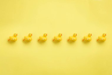 A line of yellow duckies on yellow background. clipart