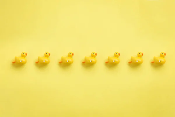 Uma Linha Patos Amarelos Fundo Amarelo — Fotografia de Stock