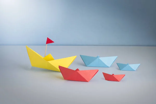 Группа Лодки Оригами Главе Большой Желтой Лодкой Синем Морском Фоне — стоковое фото