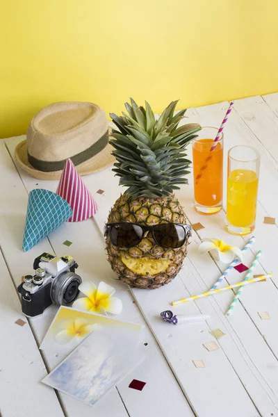 Summer party drink and pineapple on white table top conceptual still life image.