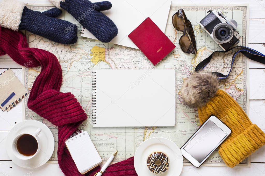 Winter travel vacation planning and objects on white outdoor cafe table top.