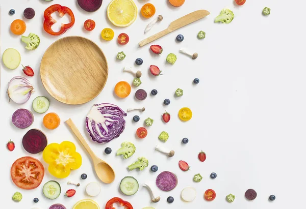 Beyaz arka planda dilimlenmiş renkli çeşitli çiğ vegan yiyecekler.