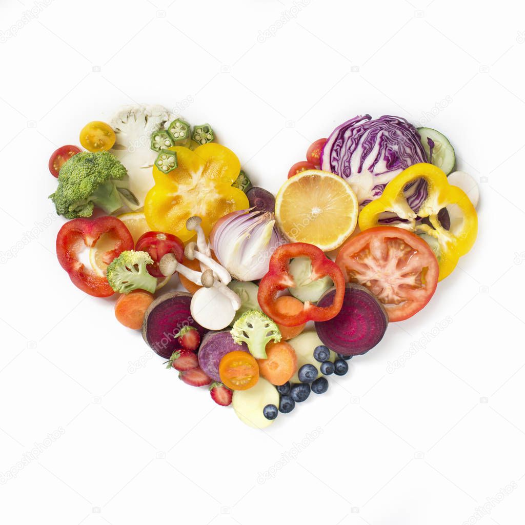 Heart shaped sliced vegan food pile in white plate.