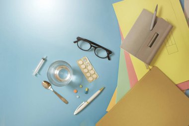 Hastalık izni kavramı görüntüsü. Ofis masasında grip ve soğuk algınlığı ilaç nesneleri.