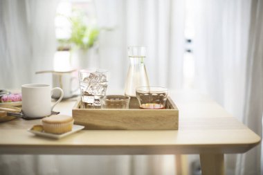 Ev yapımı içecek zamanı kupası ve bardaklar ahşap masanın üstünde.