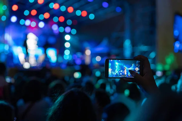 Woman recording a concert on her mobile phone